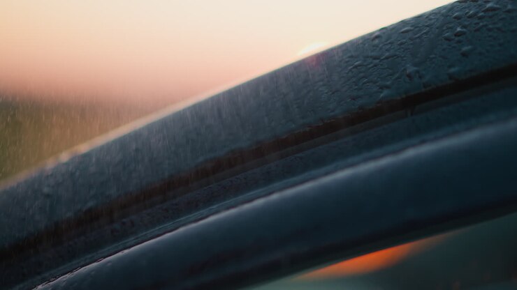 Car under rainstorm at dusk time closeup vehicle surface with clear water drops at rainstorm in