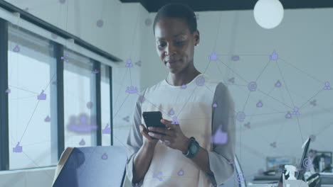 animation of connected icons over african american woman using cellphone in office