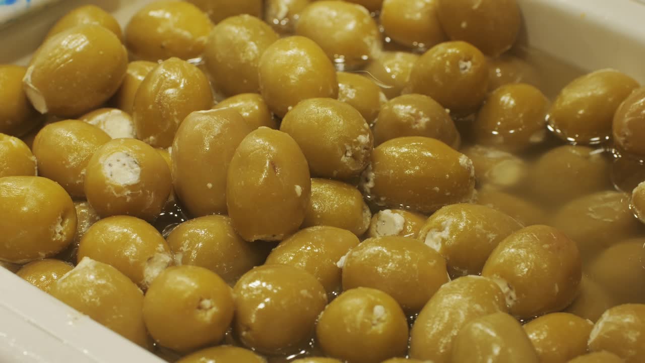 Marinated green olives in spicy sauce, spanish traditional food, ideal for Mediterranean dish or snack, market in barcelona.