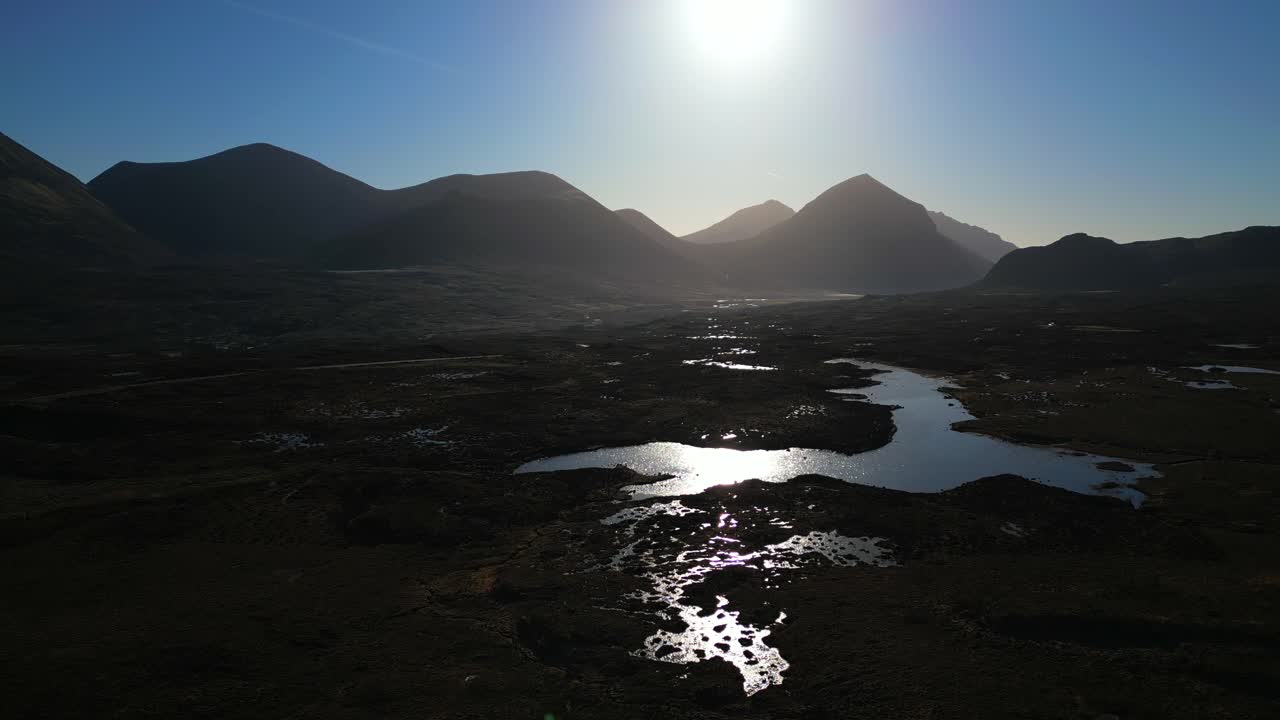 Elevando-se sobre a Natureza Selvagem Escocesa ao amanhecer com silhuetas das montanhas Cuillin em Sligachan, Ilha de Skye.