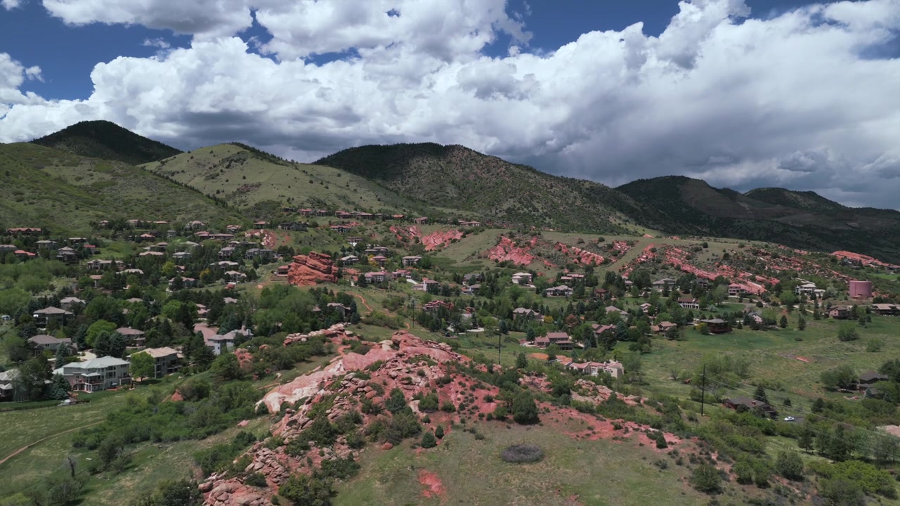 Imágenes de dron aéreo de las casas del vecindario Ken Caryl Valley Ranch y North Valley Meadow Ranch en Front Range, Denver, Colorado. Vistas de las estribaciones de las Montañas Rocosas en una mañana de verano nublada, con senderos para caminatas y Red Rocks, en movimiento hacia adelante