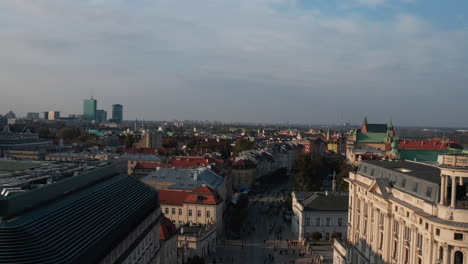 Erhöhter-Blick-Auf-Den-Historischen-Teil-Der-Stadt-In-Der-Goldenen-Stunde.-Menschen,-Die-Auf-Krakowskie,-Straße-Mit-Sehenswürdigkeiten,-Spazieren-Gehen.-Warschau,-Polen