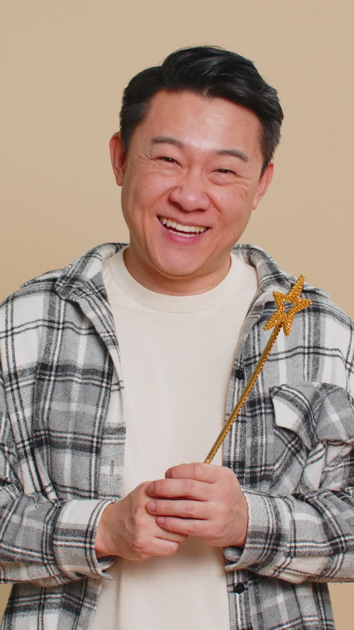 Magician witch asian man gesturing with magic wand making wish come true casting magician spell