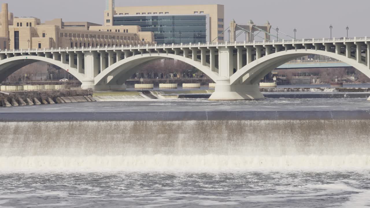 Arch Bridge With Saint Anthony Falls Of Mississippi River In Downtown Minneapolis, Minnesota, United States. Static Shot