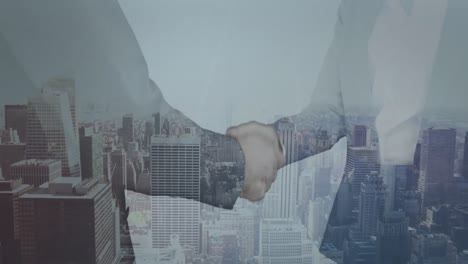 Mid-section-of-businessman-and-businesswoman-shaking-hands-against-aerial-view-of-cityscape