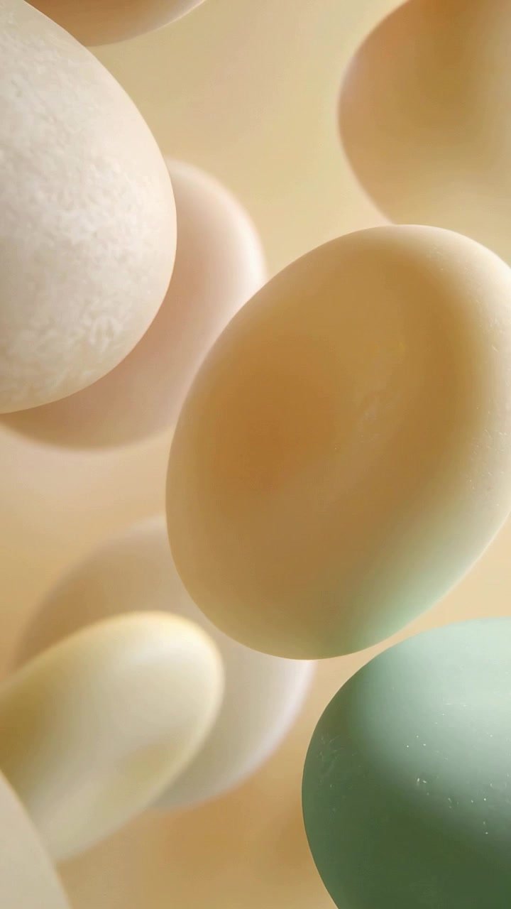 Vertical video: Drifting ovoid forms rotating under soft light in warm studio, revealing green oval