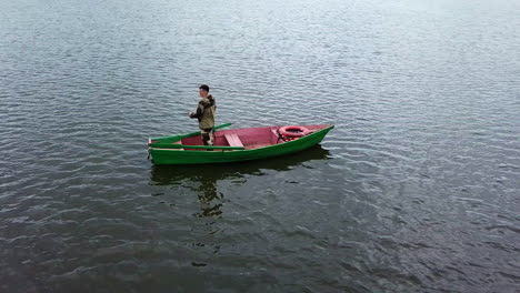 man fishing from a boat on a lake