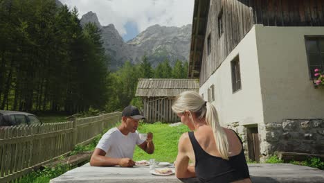 couple enjoying coffee and apple strudel outside a rustic house in the slovenian countryside