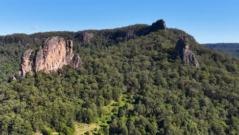 drone footage capturing the lush greenery and unique rock formations of nimbin rocks under clear blue skies