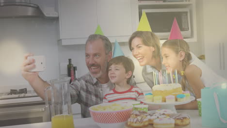 video compuesto de puntos de luz contra caucásicos tomando una selfie durante una fiesta de cumpleaños