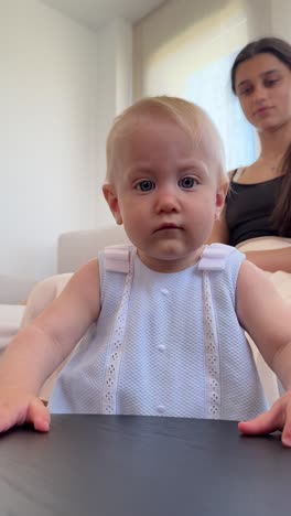 baby girl standing at a table