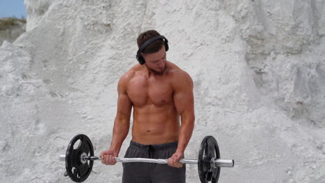 training in the open air. athletic man doing exercise wearing wireless headphones