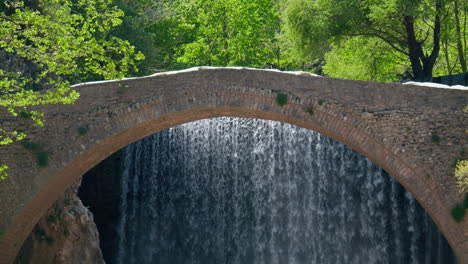 static shot old arch stone bridge waterfall slow motion background