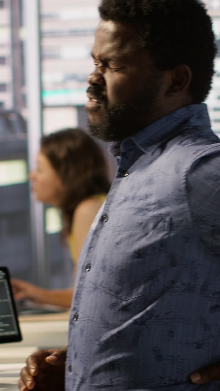 Vertical video System administrator in pain, suffering muscle sprain while working at desk