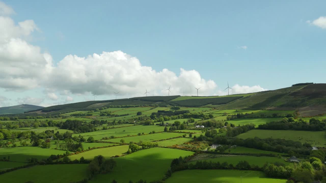 turbinas eólicas en la cima de la montaña con campos verdes en un día soleado en irlanda