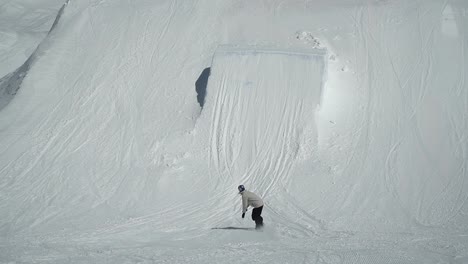 piloto profesional de snowboard saltando sobre pateador haciendo volteretas y giros en el parque de nieve en el glaciar de hintertux