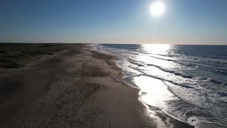 Drone-Volando-Bajo-A-La-Larga-Playa-De-Arena-En-El-Soleado,-Dinamarca,-Europa