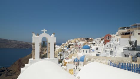 Sideways pan, white houses and blue dome churches in Santorini, Greece