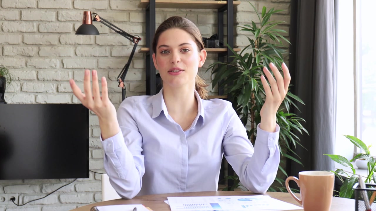 Young Woman Speaking and Gesturing During a Video Call