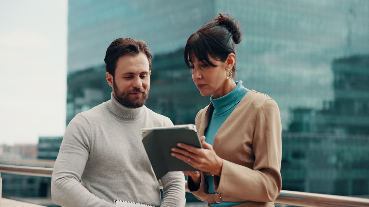 Business professionals using a tablet outdoors