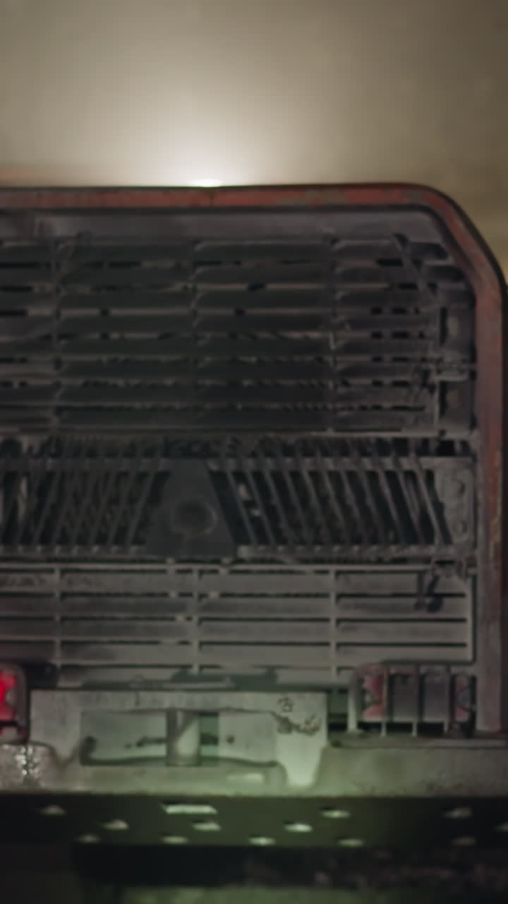 Heavy machinery with bright lights operates in dark ore mine illuminating area. Process of minerals extraction with large mining equipment closeup