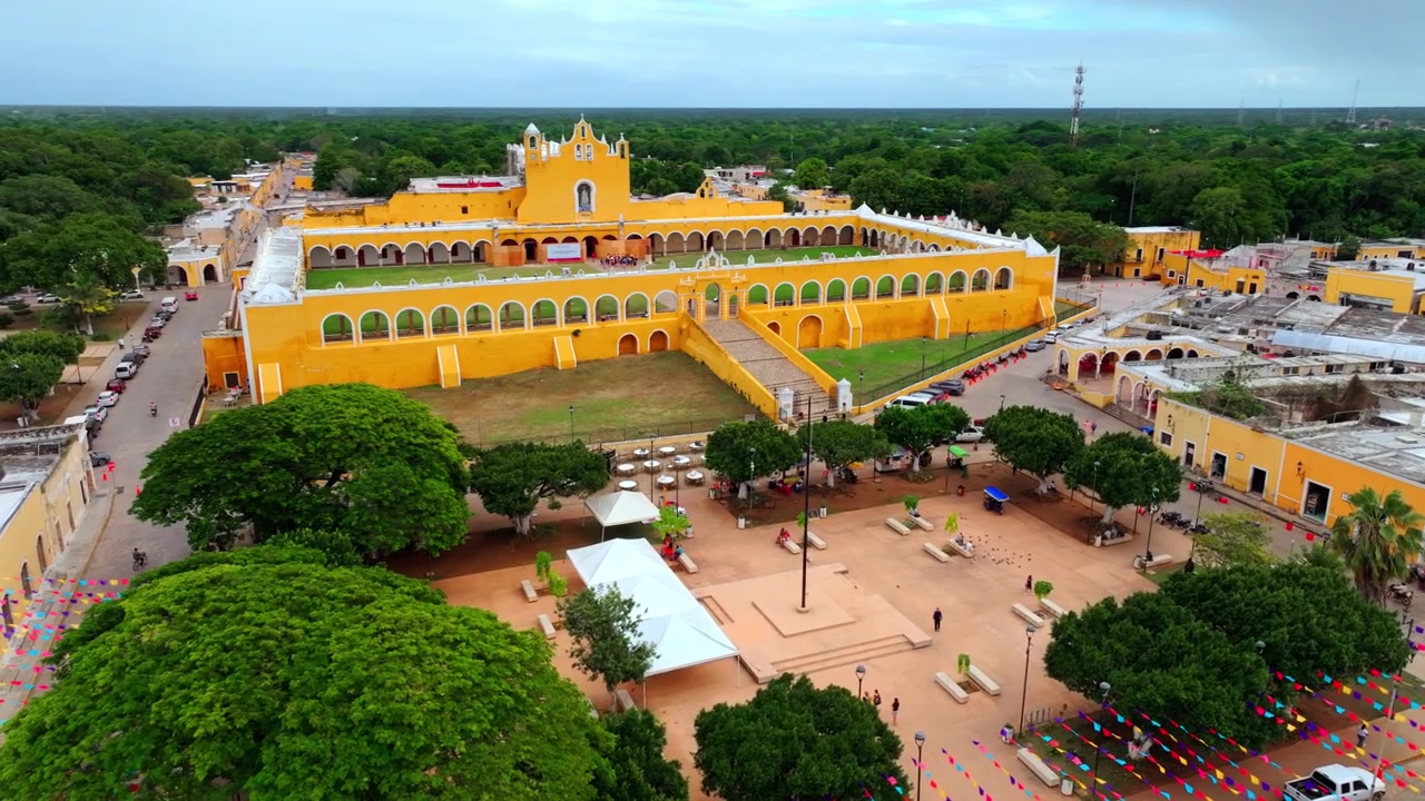Vista aérea con dron de todo el complejo del convento amarillo de San Antonio de Padua en Izamal, Yucatán, México, el monasterio colonial sobre la ciudad.