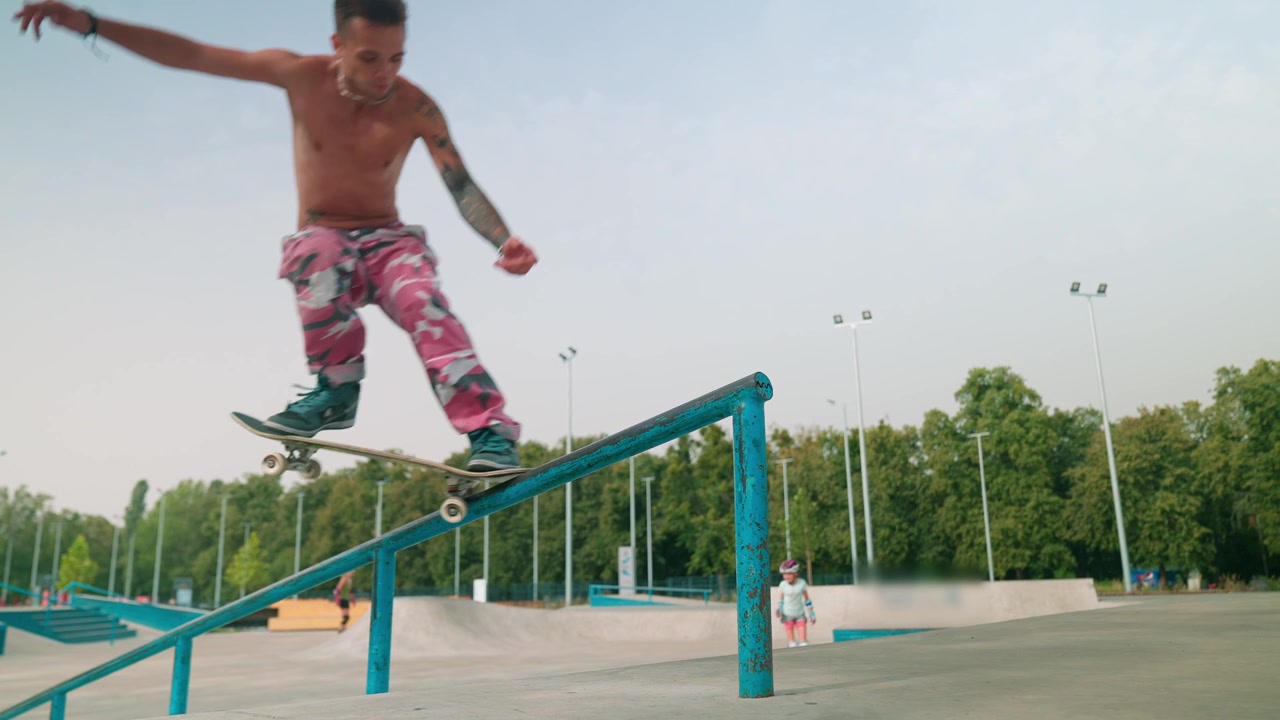 Young Man Skateboarder Grinding on a Rail at a Skatepark
