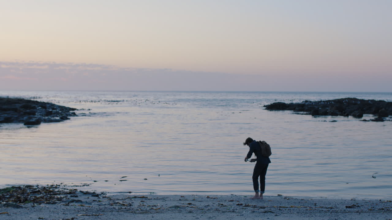 해가 지는 해변에서 걸어다니는 젊은 관광객의 초상화