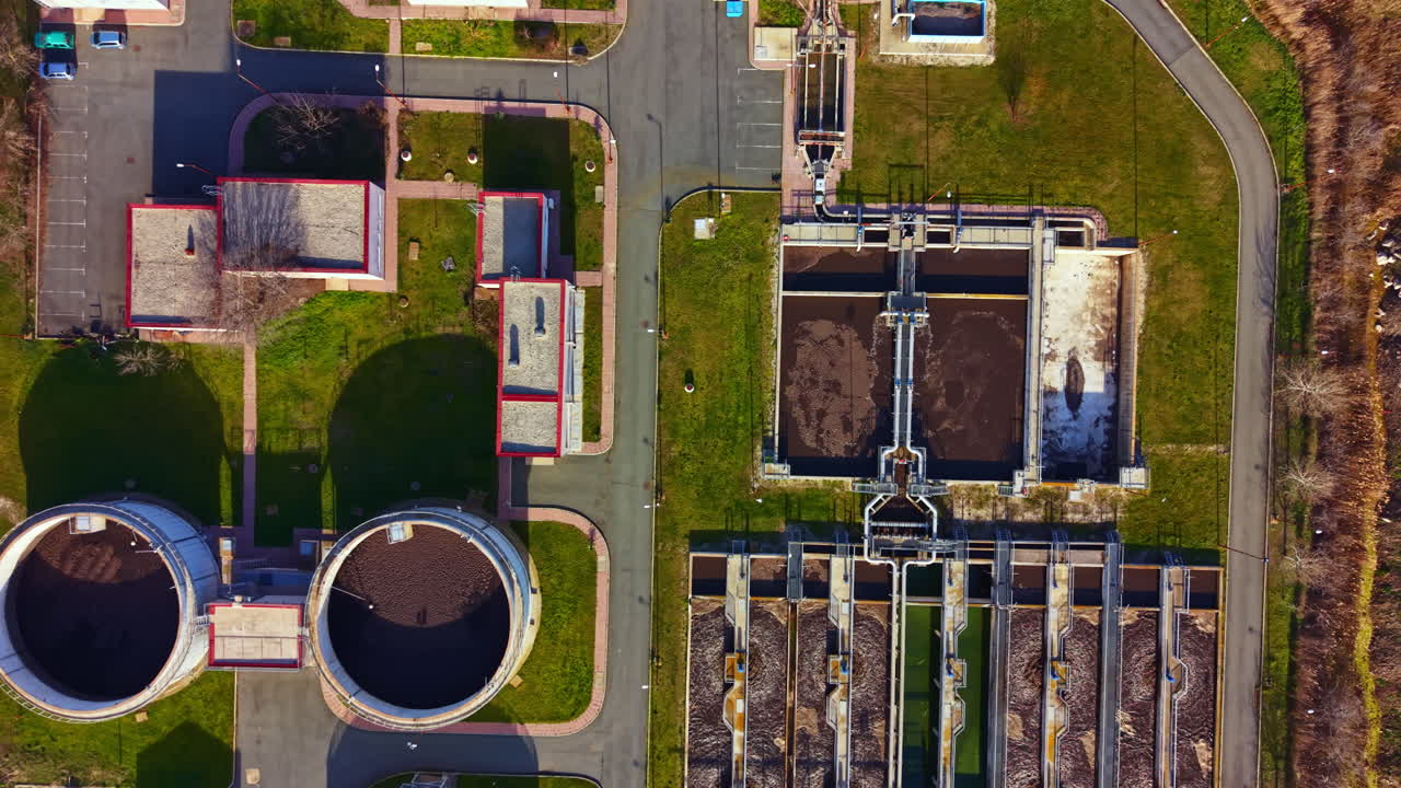 View of a wastewater treatment facility showing various tanks and treatment areas in an industrial setting during daytime