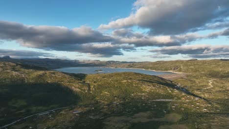 drone rising forward over sysenvatnet dam in hardangervidda with reservoir for hydropower