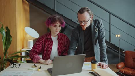 ceo explaining business plan on laptop to female employee with prosthetic arm