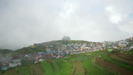 vista aérea de la pintoresca aldea rural de poombarai en las colinas de kodai bajo la nube
