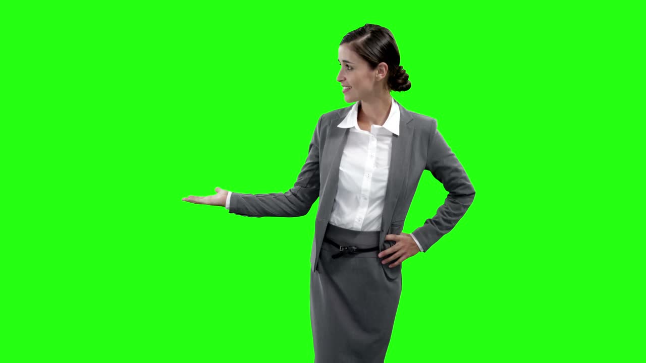 mujer de negocios haciendo gestos contra la pantalla verde