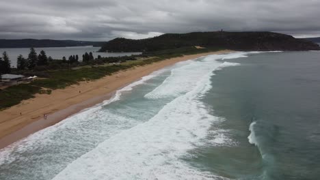 drone flying over beautiful sandy beach revealing a bay on the other side of the peninsula