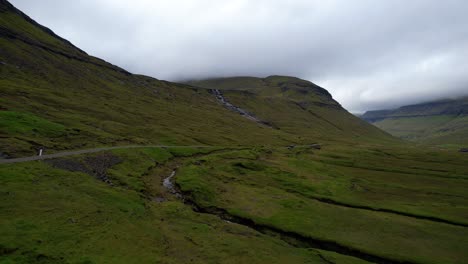 car driving in the distance along foggy mountain road, faroe islands