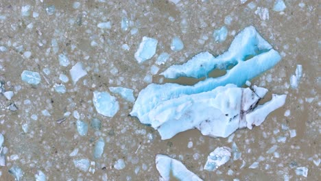 Aerial-shot-overhead-melting-icebergs-at-Fjallsárlón-due-to-global-warming,-Iceland