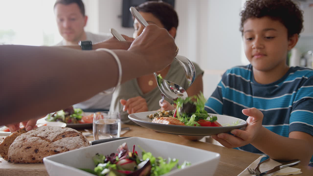 집에서 함께 테이블을 둘러싸고 식사를 하는 다세대 혼합 인종 가족
