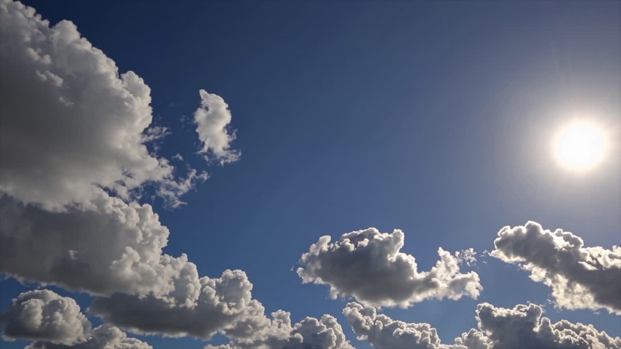 CGI time-lapse of slow-moving clouds drifting across a bright blue sky, capturing serene weather patterns and atmospheric beauty.