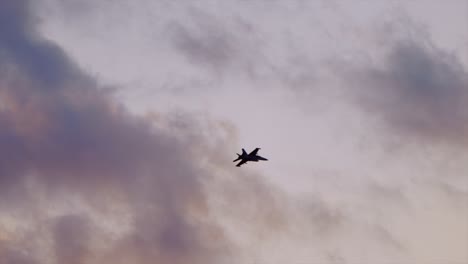 single fa-18 hornet hornet flys during sunset top gun