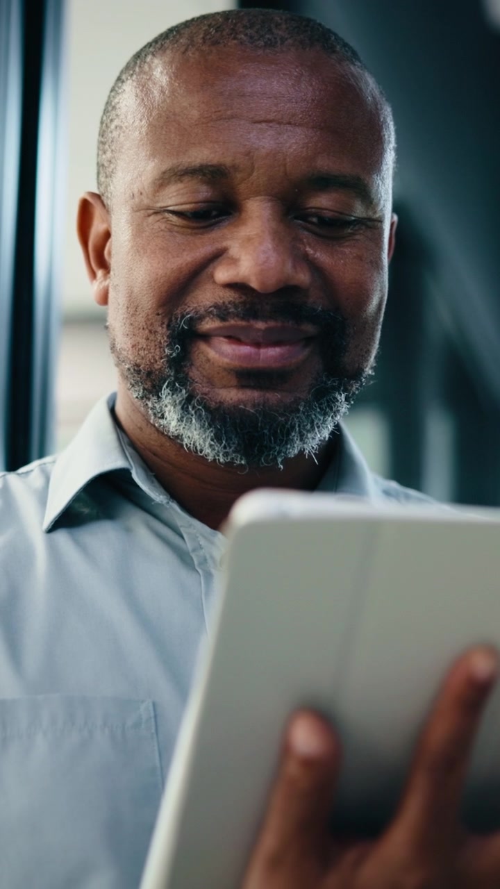 Mature Businessman Using Digital Tablet in Modern Office
