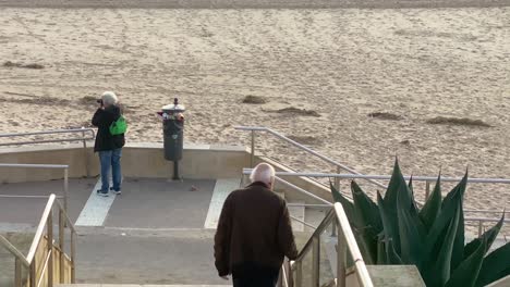 a senior man is walking to the beach in winter time