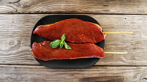 skewed raw meat garnished with basil