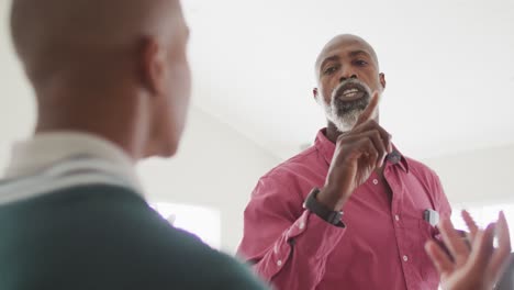 video of nervous african american father arguing with son in kitchen