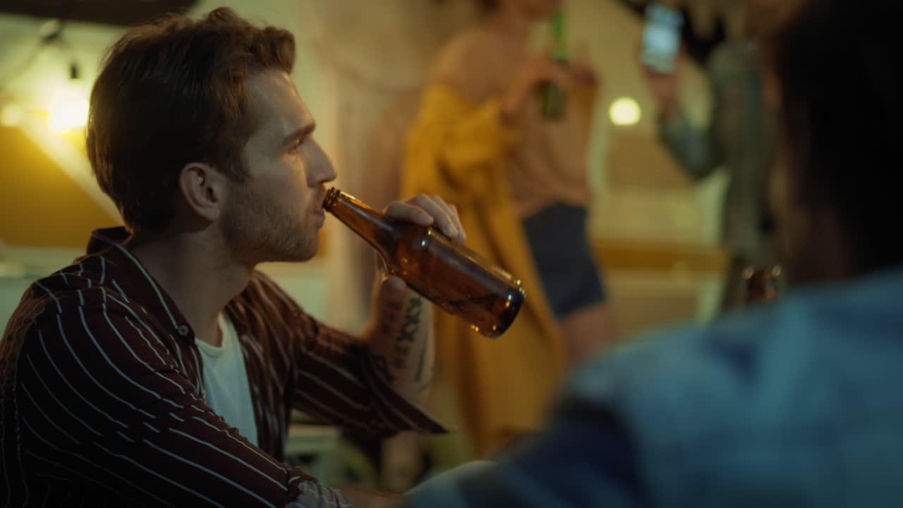 dos hombres hablando y niñas bailando en el fondo en el sitio de acampada.