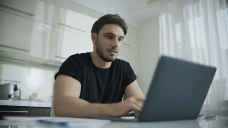 hombre feliz hablando en línea en una computadora portátil en casa. hombre sonriente hablando