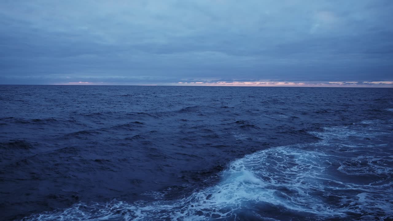 Vista del mare da una nave al tramonto con cielo e nuvole drammatici, orizzonte e acqua marina. Notte con nuvole temporalesche in un vasto e sconfinato oceano aperto. Sfondo con spazio per il testo.