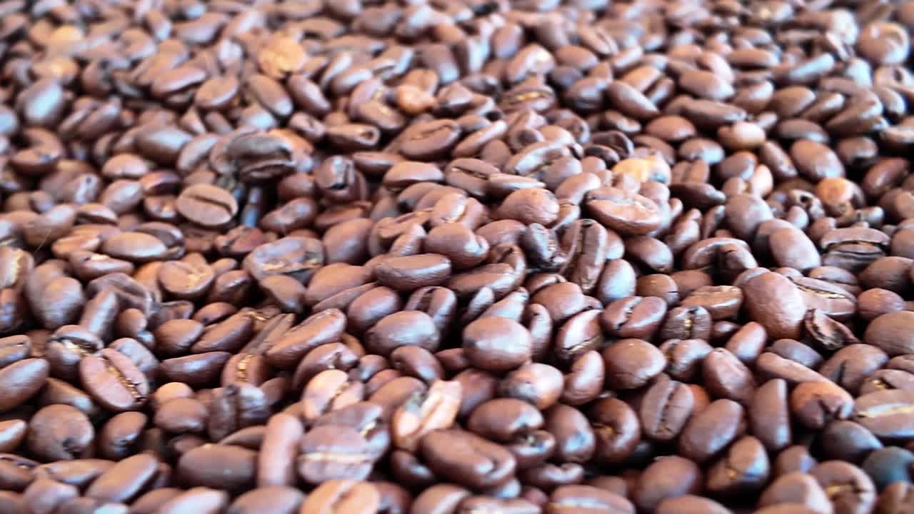 Primo piano di chicchi di caffè, contrasti tra tostati e freschi.