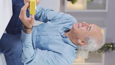 Vertical-video-of-Old-man-waiting-for-someone-with-gift-box.