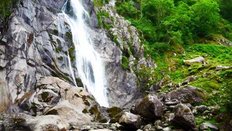 Flowing-rocky-mountain-valley-waterfall-in-relaxing-forest-foliage-wilderness