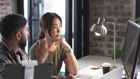 Young-Asian-man-and-Asian-woman-are-engaged-in-a-business-conversation-at-an-office